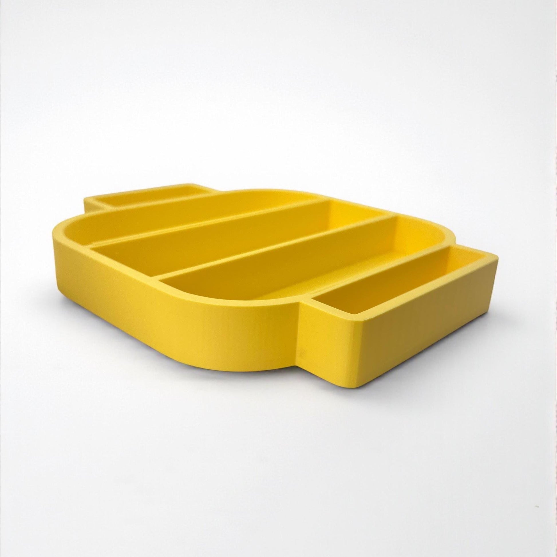 Close-up of the edge of the yellow LEGO-style shelf, highlighting smooth 3D printed finish and compartment shape.
