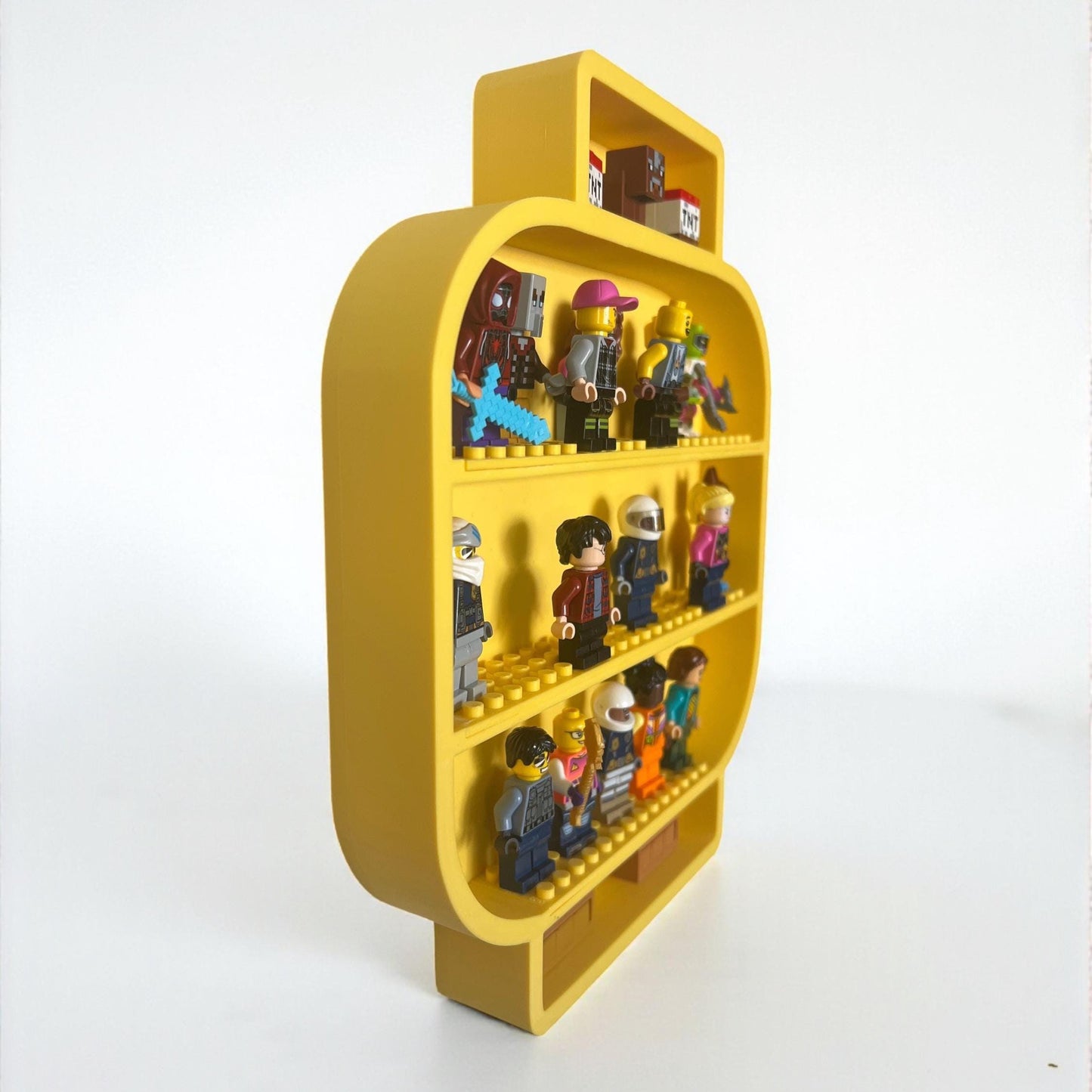 Side angle view of yellow LEGO-style minifigure head shelf showing depth and compartments filled with toy minifigures