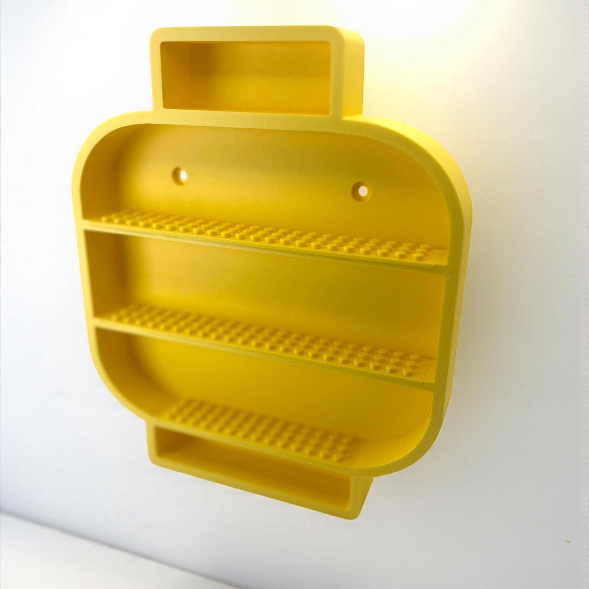 Angled perspective of yellow LEGO-inspired display shelf showing depth and inner compartments.